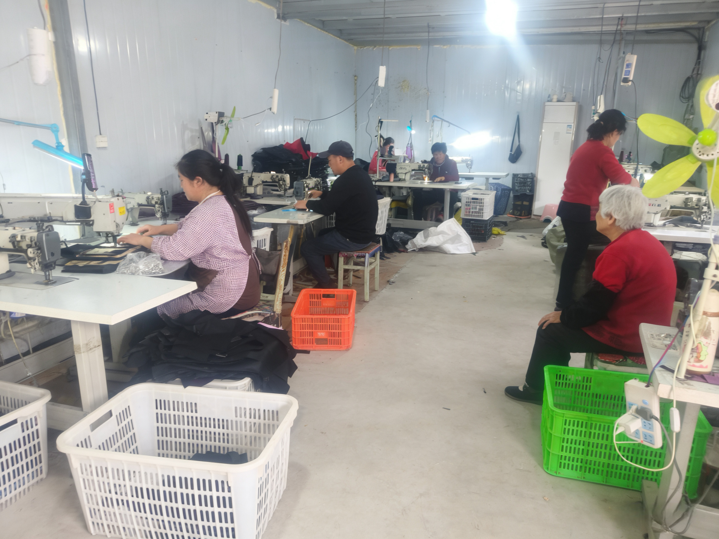 现代化箱包生产车间,配备先进设备,工人正在操作机器进行生产作业,明亮整洁的厂房环境